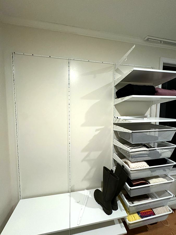 Closet shelving system mounted on a wall with drawers and shelves