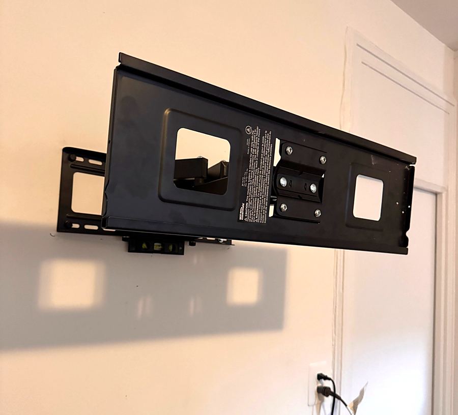 TV wall mount bracket installed on a wall with a level on it